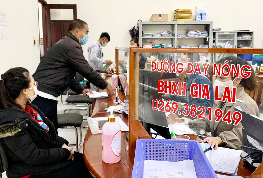 Nhân viên BHXH tỉnh hướng dẫn người dân các thủ tục, chính sách liên quan BHXH, BHYT. Ảnh: Như Nguyện