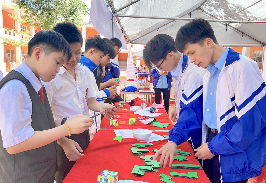 Học sinh Trường THPT chuyên Hùng Vương (bìa phải) hướng dẫn các em nhỏ tham gia trò chơi trải nghiệm Toán học tại MOD 2022. Ảnh: Mộc Trà