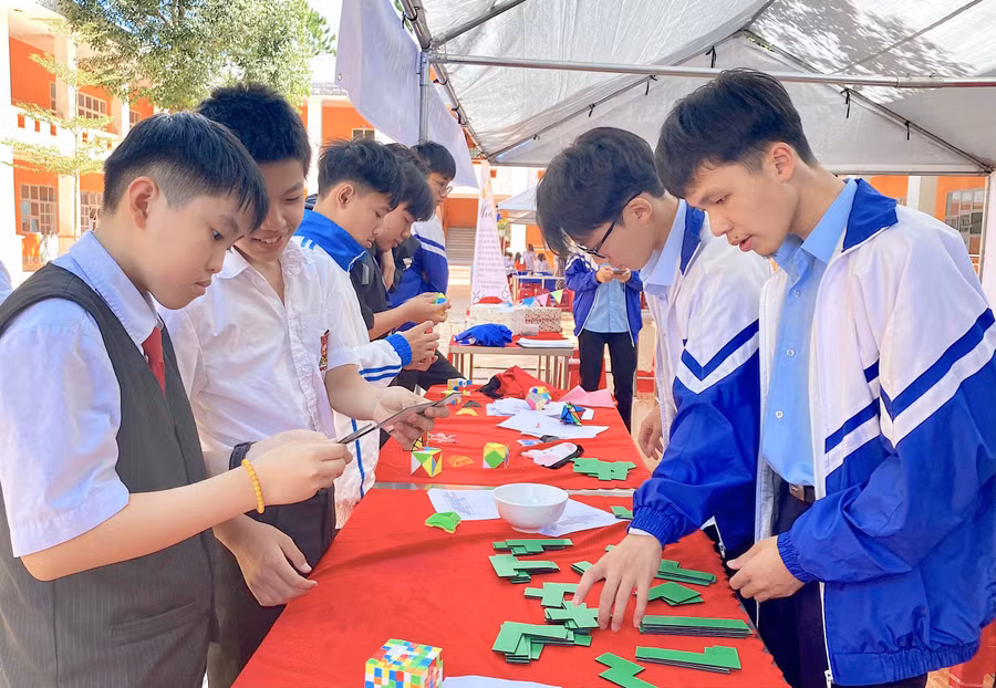 Học sinh Trường THPT chuyên Hùng Vương (bìa phải) hướng dẫn các em nhỏ tham gia trò chơi trải nghiệm Toán học tại MOD 2022. Ảnh: Mộc Trà