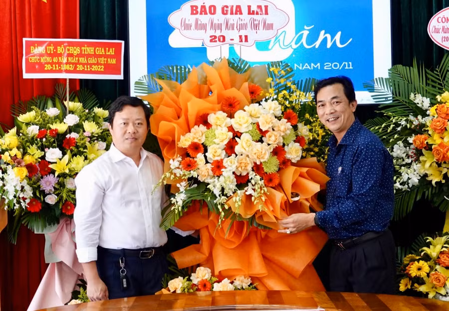 Ông Lương Văn Danh (bìa phải)-Phó Tổng Biên tập Báo Gia Lai tặng hoa chúc mừng đội ngũ cán bộ, nhân viên Sở Giáo dục và Đạo tạo nhân kỷ niệm 40 năm Ngày Nhà giáo Việt Nam. Ảnh: Mộc Trà