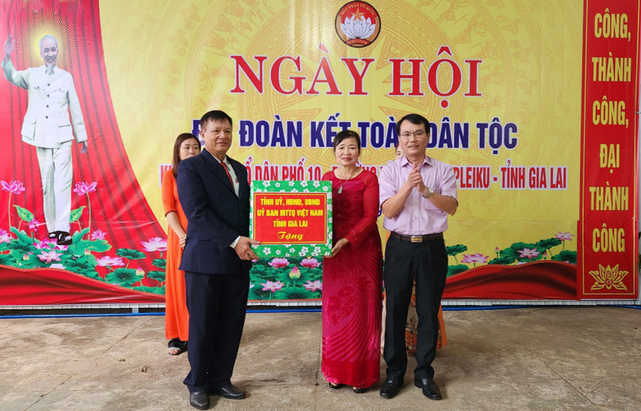 Đồng chí Trịnh Duy Thuân tặng quà của Tỉnh ủy, HĐND, UBND, Ủy ban MTTQ Việt Nam tỉnh cho bà con tổ dân phố 10. Ảnh: Ngọc Sang