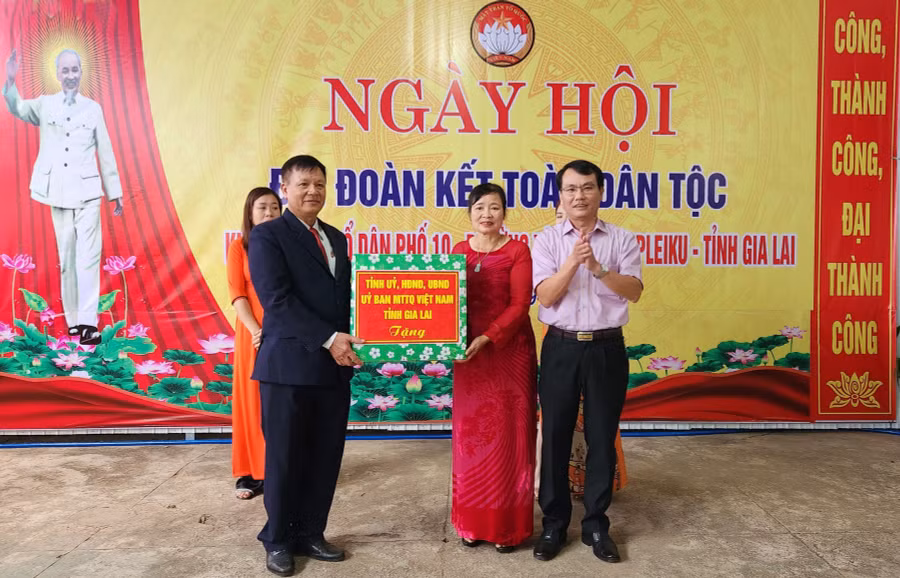 Đồng chí Trịnh Duy Thuân tặng quà của Tỉnh ủy, HĐND, UBND, Ủy ban MTTQ Việt Nam tỉnh cho bà con tổ dân phố 10. Ảnh: Ngọc Sang