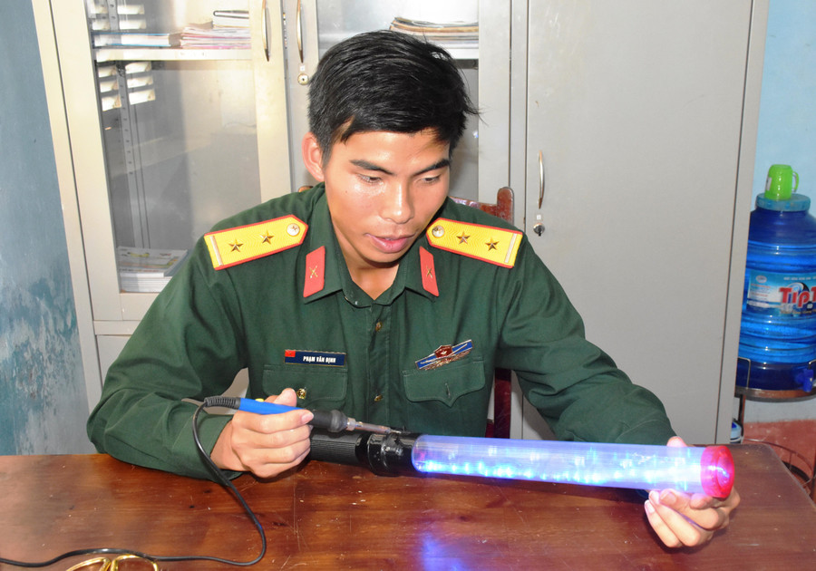 Trung úy Phạm Văn Định kiểm tra thiết bị “Cờ chỉ huy ban đêm”. Ảnh: Vĩnh Hoàng