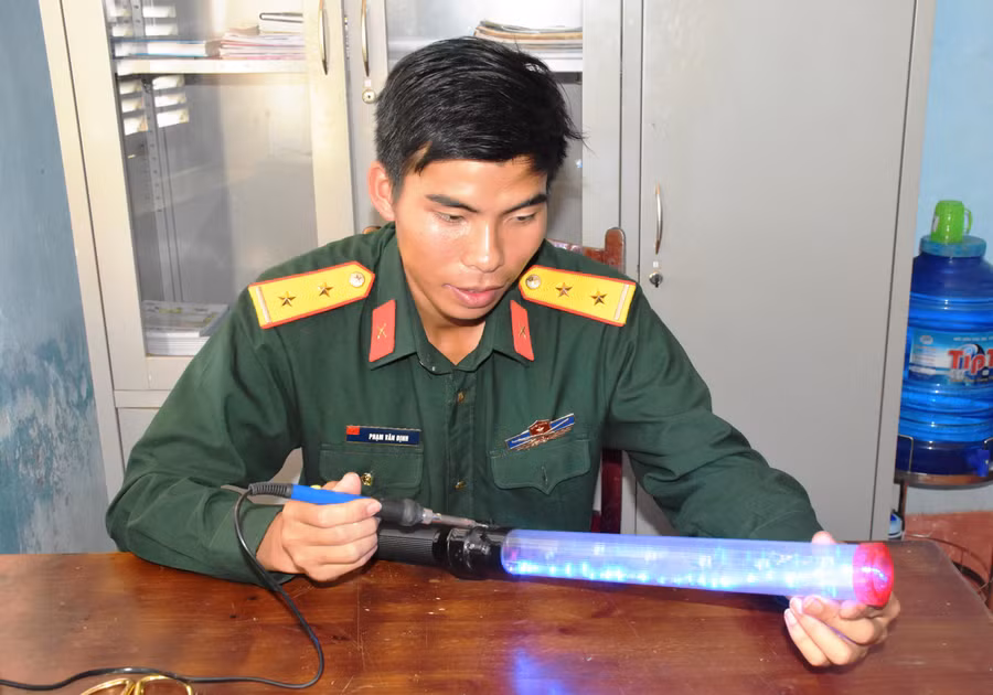 Trung úy Phạm Văn Định kiểm tra thiết bị “Cờ chỉ huy ban đêm”. Ảnh: Vĩnh Hoàng