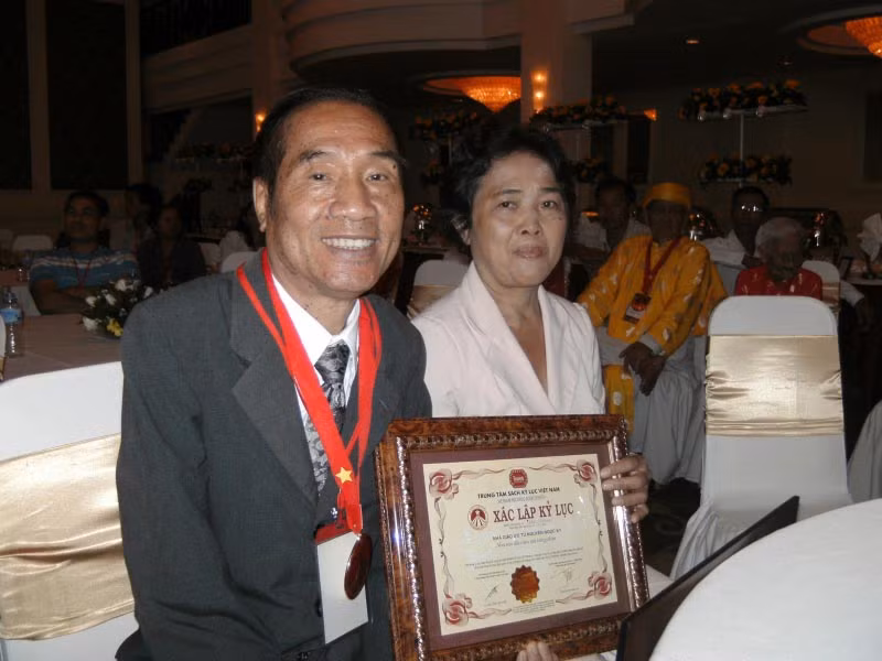 Vợ chồng thầy giáo Nguyễn Ngọc Ký trong lần đón nhận Kỷ lục gia Việt Nam cho người đầu tiên viết sách bằng chân.