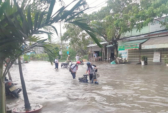 Học sinh vật lộn với dòng nước lớn để về nhà.