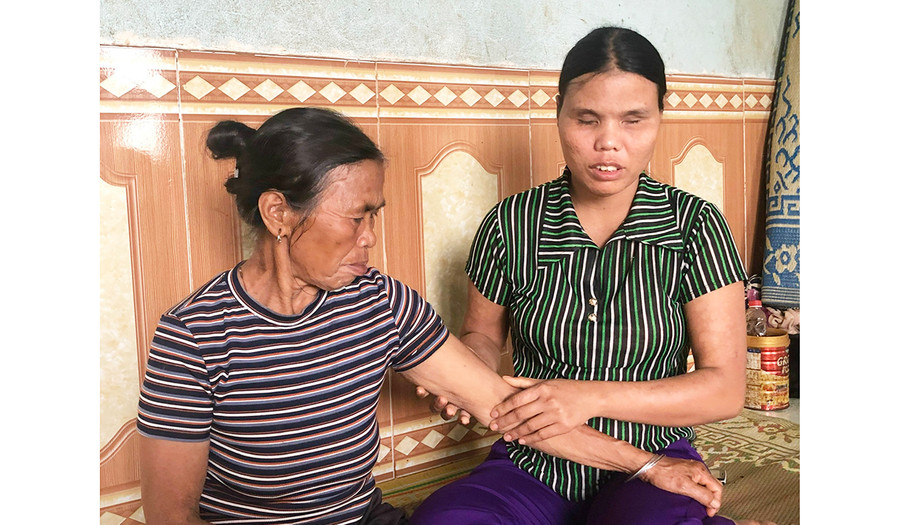 Chị Kpă Roeh (bìa phải) xoa bóp tay chân cho mẹ. Ảnh: Anh Huy Chị Kpă Roeh (bìa phải) xoa bóp tay chân cho mẹ. Ảnh: Anh Huy