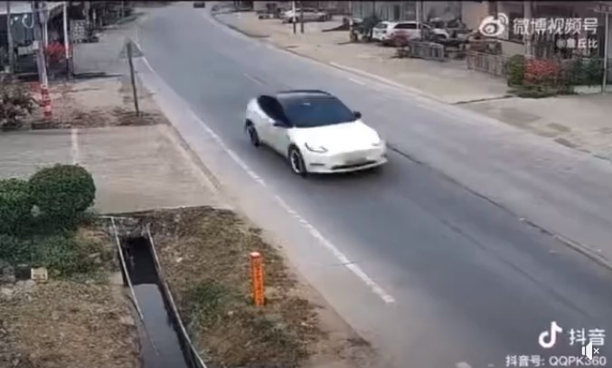 Chiếc Tesla Model Y màu trắng lao như bay trước khi lao vào người đi đường. Ảnh chụp màn hình Chiếc Tesla Model Y màu trắng lao như bay trước khi lao vào người đi đường. Ảnh chụp màn hình