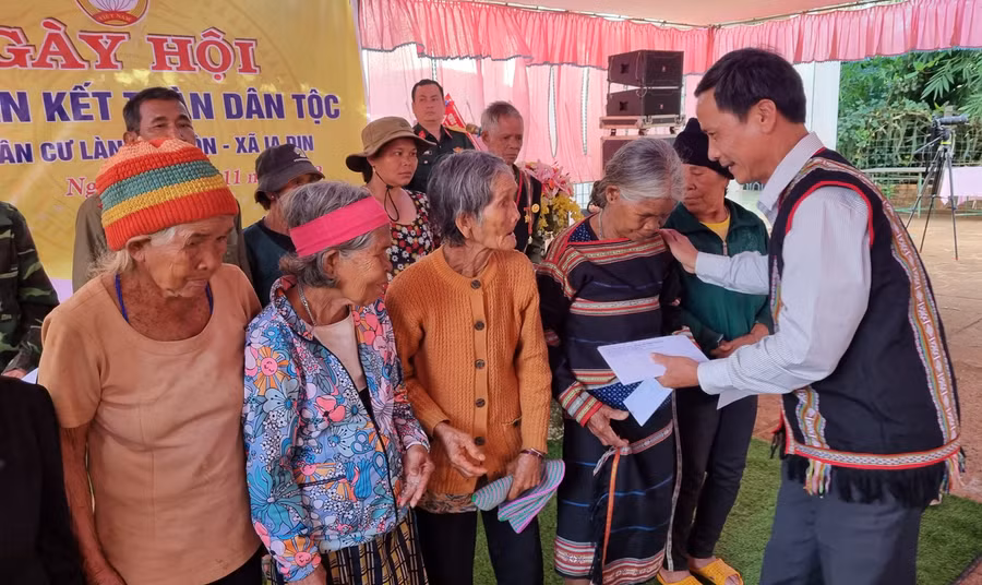 Ông Nguyễn Như Trình-Trưởng Ban Quản lý Khu kinh tế tỉnh trao quà cho các gia đình chính sách tại làng Al Gôn. Ảnh: Hà Phương