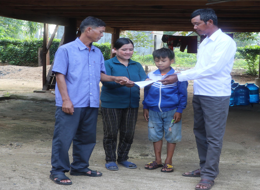 Ông Đinh Hréch-Bí thư Chi bộ kiêm Trưởng thôn Brò (bìa phải, xã An Trung, huyện Kông Chro) tuyên truyền người dân thực hiện nghiêm các quy định trong hương ước. Ảnh: Ngọc Minh 