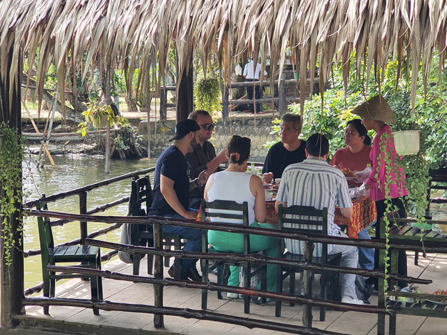 Du khách nước ngoài trải nghiệm ẩm thực Nam bộ tại Cồn Phụng. Ảnh: Khang Ka 