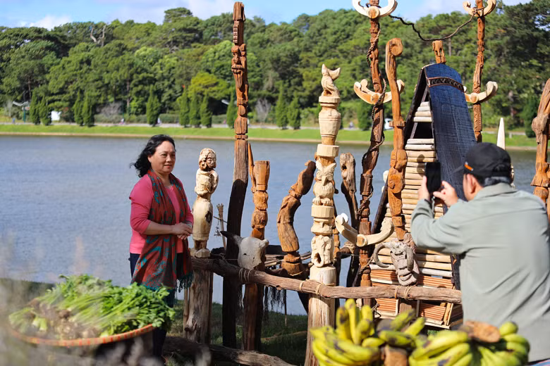 Du khách thích thú chiêm ngưỡng, chụp hình lưu niệm bên cả trăm bức tượng gỗ Tây Nguyên bên hồ Xuân Hương thơ mộng