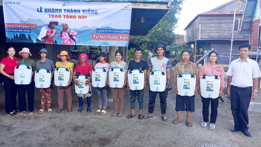 Bà Trịnh Thị Thanh Hồng-Chủ tịch Hội Chữ thập đỏ huyện (áo đỏ) cùng lãnh đạo UBND xã Pờ Tó trao tặng gùi chứa nước cho bà con. Ảnh: Mai Linh