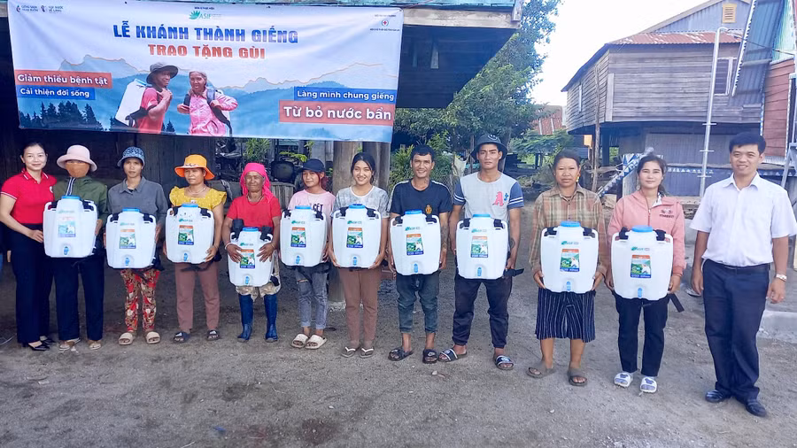 Bà Trịnh Thị Thanh Hồng-Chủ tịch Hội Chữ thập đỏ huyện (áo đỏ) cùng lãnh đạo UBND xã Pờ Tó trao tặng gùi chứa nước cho bà con. Ảnh: Mai Linh