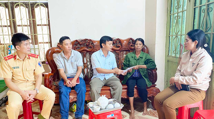  Đại diện Ban An toàn giao thông huyện tặng quà cô Thúy mẹ của nạn nhân T.Đ.V. tại thôn Bình Tây, xã Chư Răng. Ảnh: Mai Linh