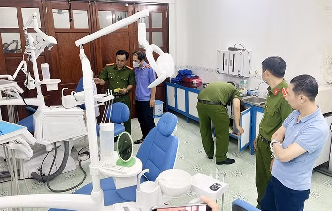 Lực lượng chức năng khám xét nơi làm việc của Tú. Ảnh CAAG.