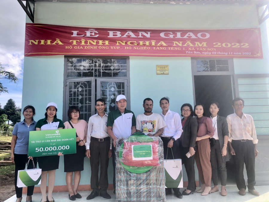 Đại diện lãnh đạo Vietcombank Chi nhánh Bắc Gia Lai và chính quyền địa phương chúc mừng gia đình anh Yup có nơi ở mới. Ảnh: Sơn Ca