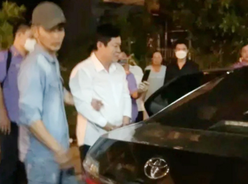 Cơ quan điều tra Viện KSND Tối cao dẫn giải ông Mỹ (áo trắng) ra xe.