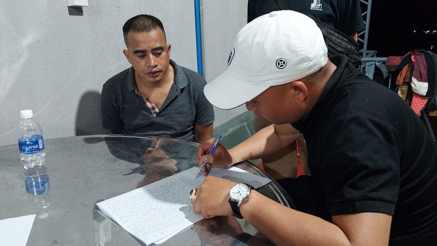 Lê Đình Sang (trái) tại cơ quan công an. Ảnh Công an cung cấp