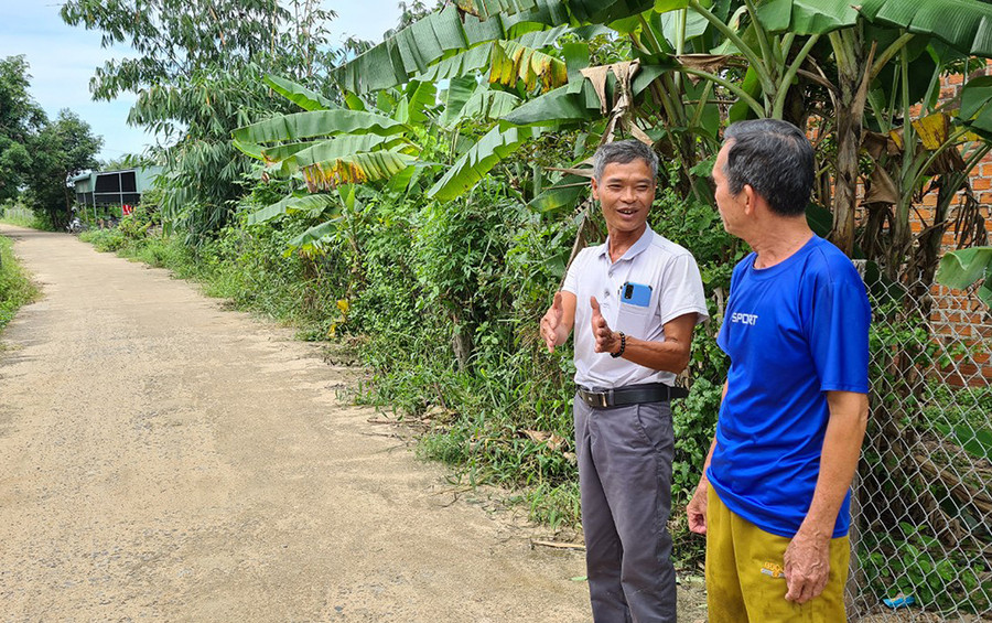 Ông Đinh Trí Kiên (bên trái) trao đổi với người dân về việc lắp đặt camera an ninh trên các tuyến đường. Ảnh: Phạm Ngọc