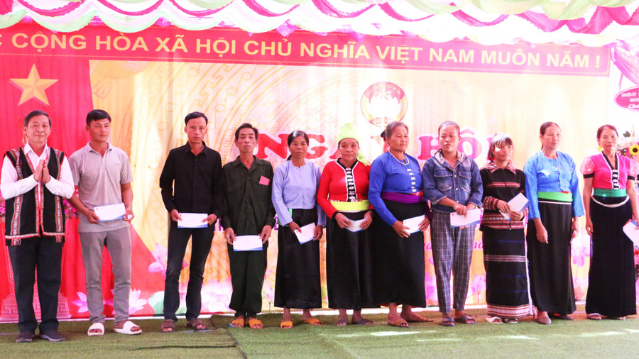 Trưởng ban Tuyên giáo Tỉnh ủy Huỳnh Thế Mạnh tặng 10 suất quà cho 10 hộ nghèo của thôn. Ảnh: Quang Tấn