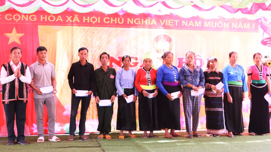 Trưởng ban Tuyên giáo Tỉnh ủy Huỳnh Thế Mạnh tặng 10 suất quà cho 10 hộ nghèo của thôn. Ảnh: Quang Tấn