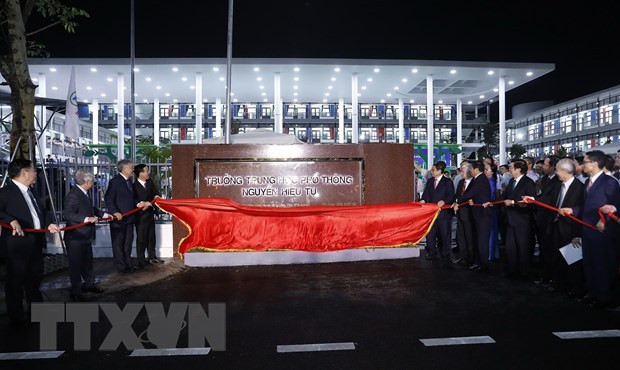 Thủ tướng Phạm Minh Chính và các đại biểu thực hiện nghi thức kéo băng khánh thành Trường Trung học phổ thông Nguyễn Hiếu Tự. (Ảnh: Dương Giang/TTXVN)