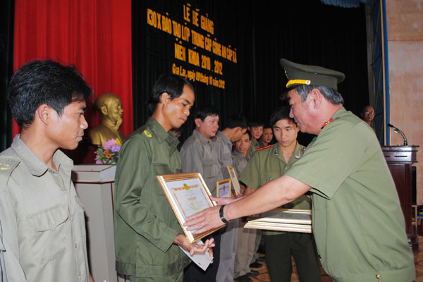 Đại tá Nguyễn Duy Lanh-Phó Giám đốc Công an tỉnh trao giấy khen cho các cá nhân có thành tích xuất sắc lớp Trung cấp Công an xã niên khóa 2010-2012. Ảnh: H.T
