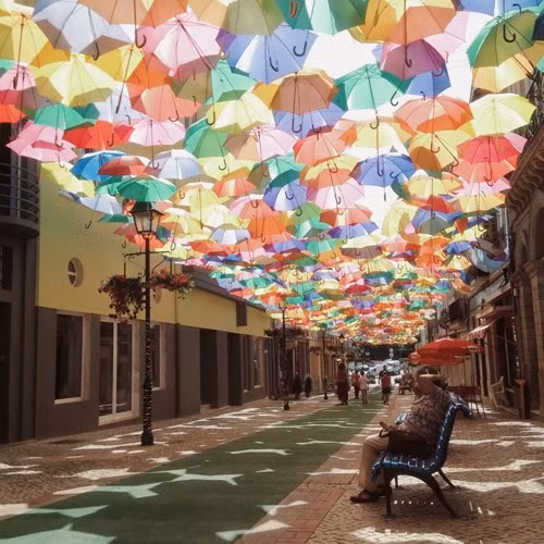  Một con đường tại thành phố Águeda, Bồ Đào Nha trong mùa Lễ hội Nghệ thuật Ágitagueda 2011. Khách bộ hành bị mê hoặc hoàn toàn bởi con đường được che ô này. 