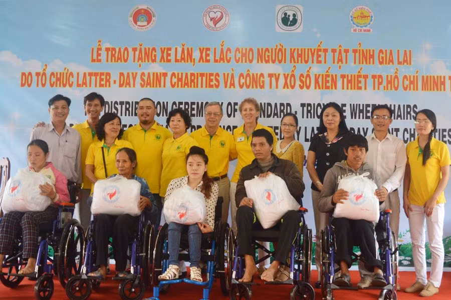 Tặng xe lăn cho người khuyết tật. Ảnh: Đinh Yến