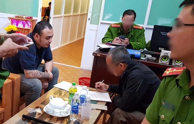 Công an làm việc với Hoàng Công Minh (áo thun, ngồi bên trái) ẢNH: GIA BÌNH