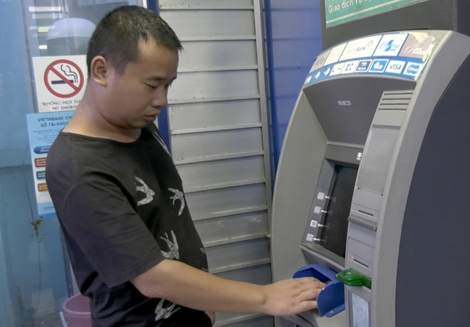 Tằng Cẩm Bằng bị cảnh sát tạm giữ sau khi rút tiền bằng thẻ ATM giả. Ảnh: Tuấn Thanh.