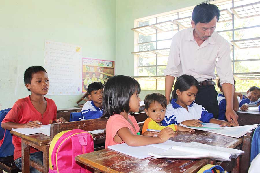  Thầy Lưu Văn Thống kiểm tra bài viết của Trang. Ảnh: N.G