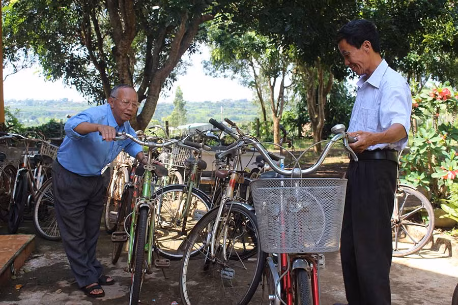  Ông Nguyễn Xuân Tảo (bìa trái)-Chủ tịch Hội Khuyến học xã Dun, huyện Chư Sê-kiểm tra lại xe đạp trước khi tặng học sinh nghèo. Ảnh: N.G 