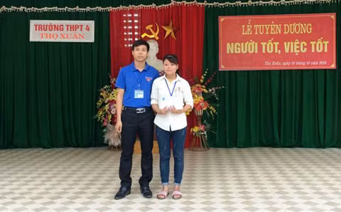 Thầy giáo Phạm Văn Thiện (bìa trái) sau khi nhận được tiền thưởng đã tặng lại học sinh Hoàng Thị Oanh 