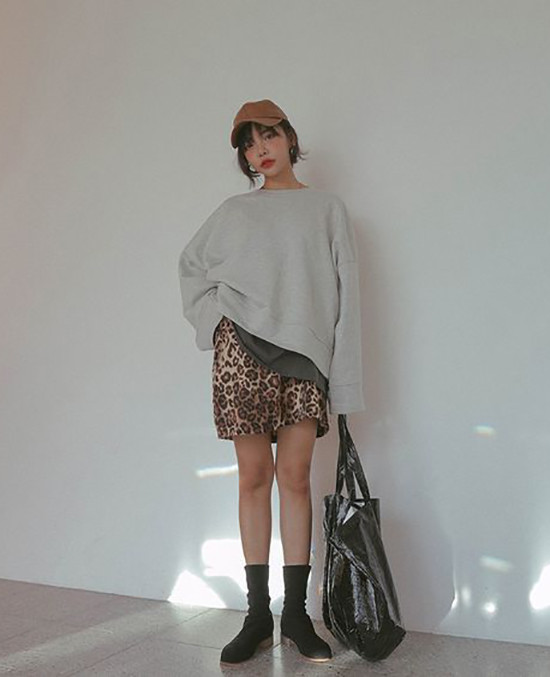 Set đồ trẻ trung phù hợp đi dạo phố, mua sắm và hẹn hò cà phê cùng bạn bè vào ngày nghỉ. Quần short da beo ống rộng được kết hợp cùng áo hoodie, bốt cổ thấp.