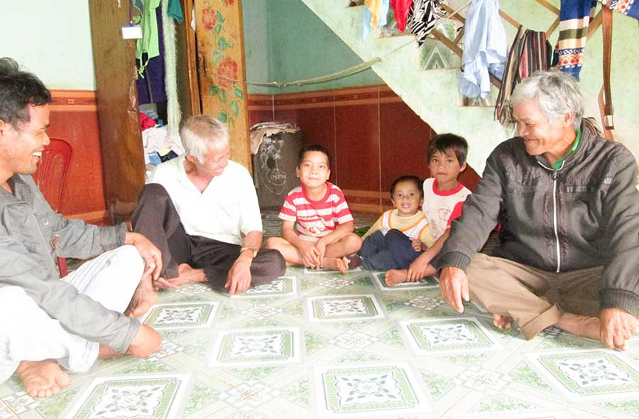 Già làng Rơ Châm Ly (áo đen bên phải) thường xuyên tới từng nhà động viên các cháu tới trường. Ảnh: Trần Dung Già làng Rơ Châm Ly (áo đen bên phải) thường xuyên tới từng nhà động viên các cháu tới trường. Ảnh: Trần Dung