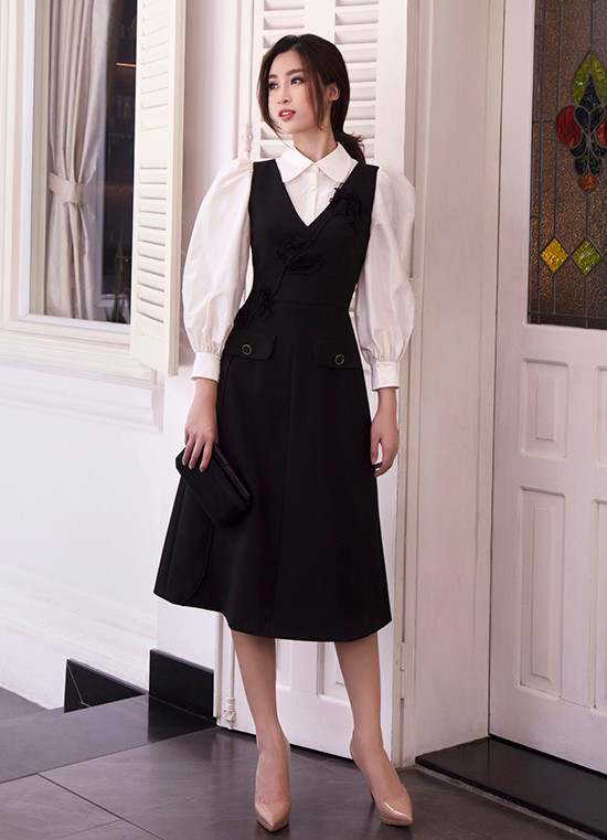  Sơ mi tay bồng được kết hợp cùng mẫu váy xoè sát nách theo phong cách cổ điển. Để tăng sức hút cho bộ cánh đi tiệc nhẹ, nhà thiết kế đã trang trí hoạ tiết cánh hoa thêu to bản trên thân váy.