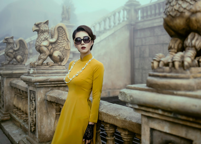 Người đẹp 36 tuổi trông như quý cô thời xưa khi mặc áo dài, búi tóc chỉn chu, đeo vòng cổ ngọc trai và nhấn nhá găng tay ren đen. Người đẹp 36 tuổi trông như quý cô thời xưa khi mặc áo dài, búi tóc chỉn chu, đeo vòng cổ ngọc trai và nhấn nhá găng tay ren đen.