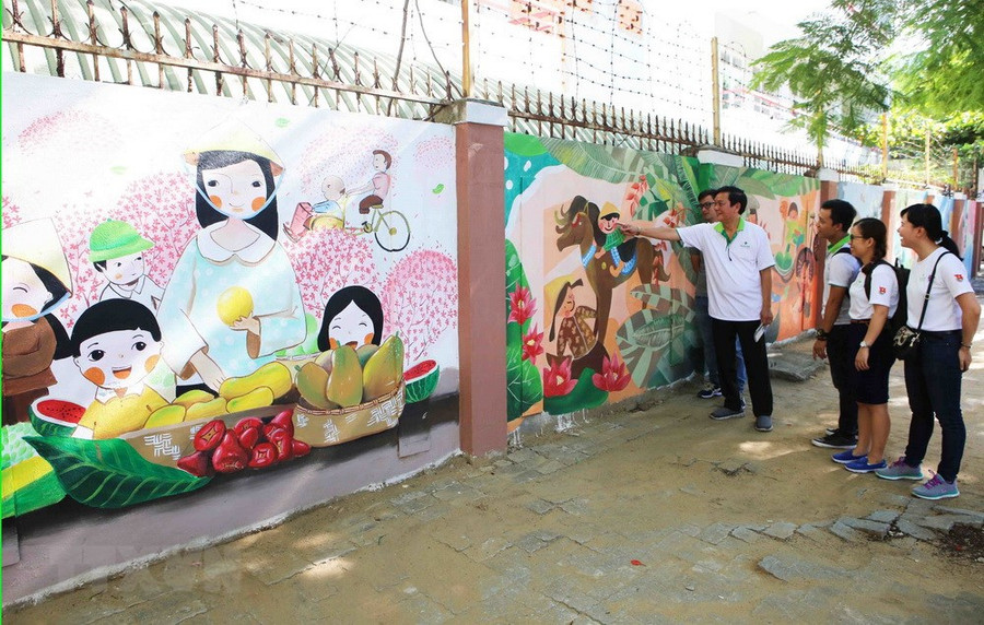 Người dân tham quan con đường bích họa 'Bừng sáng cuộc sống.' (Ảnh: Trần Lê Lâm/TTXVN)