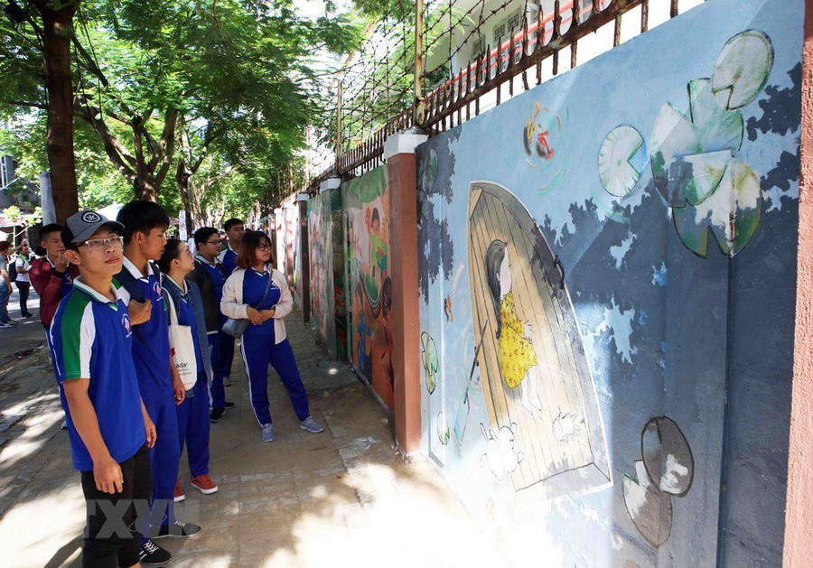 Từ những mảng tường rêu mốc, hư hỏng, 7 họa sỹ cùng đông đảo đoàn viên, thanh niên và người dân chung tay dọn vệ sinh sạch sẽ và thực hiện vẽ 30 bức tranh. (Ảnh: Trần Lê Lâm/TTXVN)