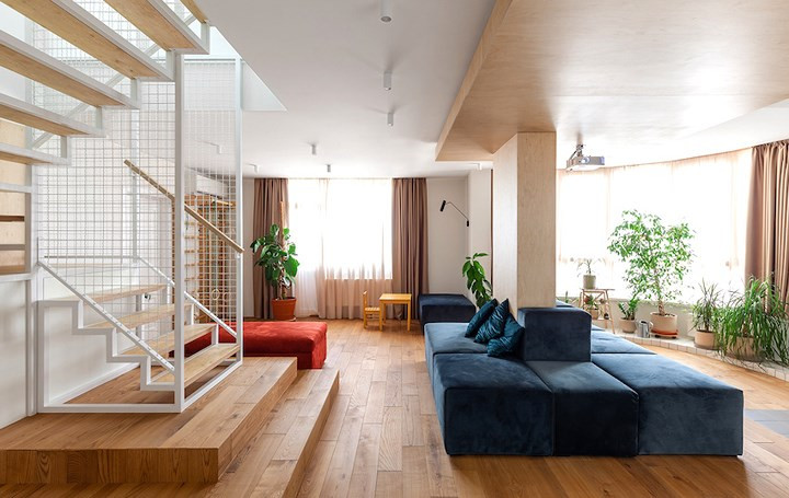  Sàn nhà lát gỗ ấm cúng tạo cảm giác tương phản với trần bê tông màu trắng.