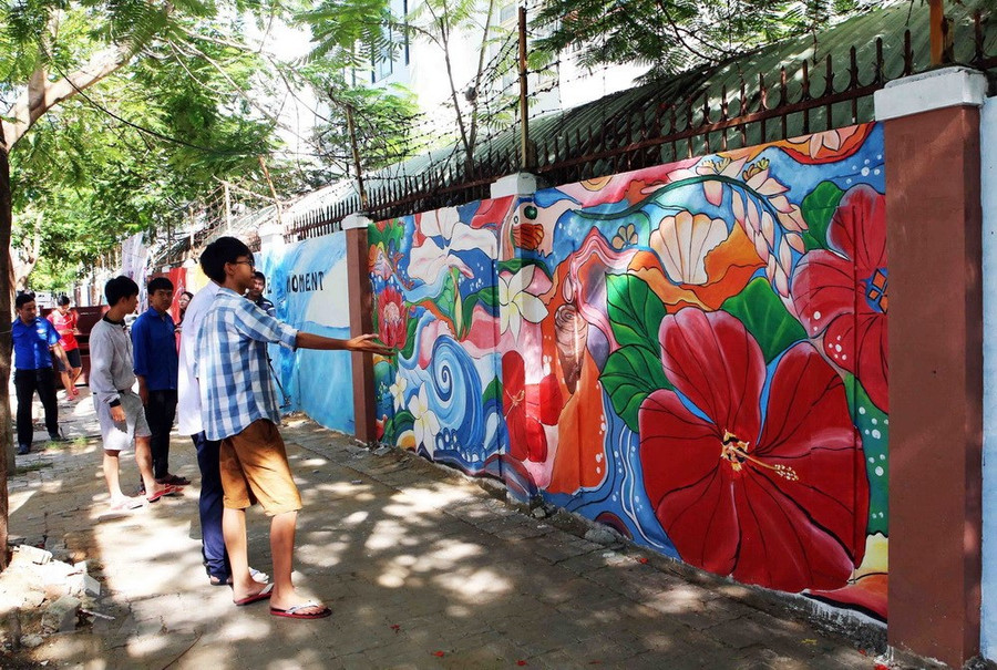 Người dân tham quan con đường bích họa 'Bừng sáng cuộc sống.' (Ảnh: Trần Lê Lâm/TTXVN)