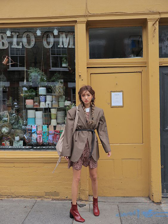 Váy in hoạ tiết hot trend được sử dụng cùng vest vai ngang, bốt da đỏ để tăng nét cá tính cho trang phục mùa thu đông.