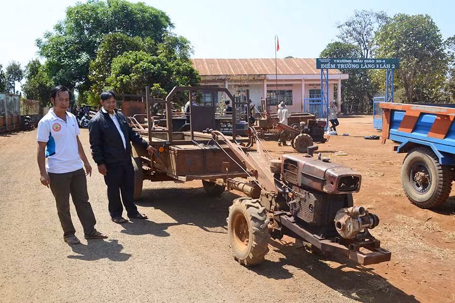  Người dân làng Klăh 2 (xã Ia Dêr, huyện Ia Grai) gắn biển số, biển phản quang vào xe công nông. Ảnh: H.C