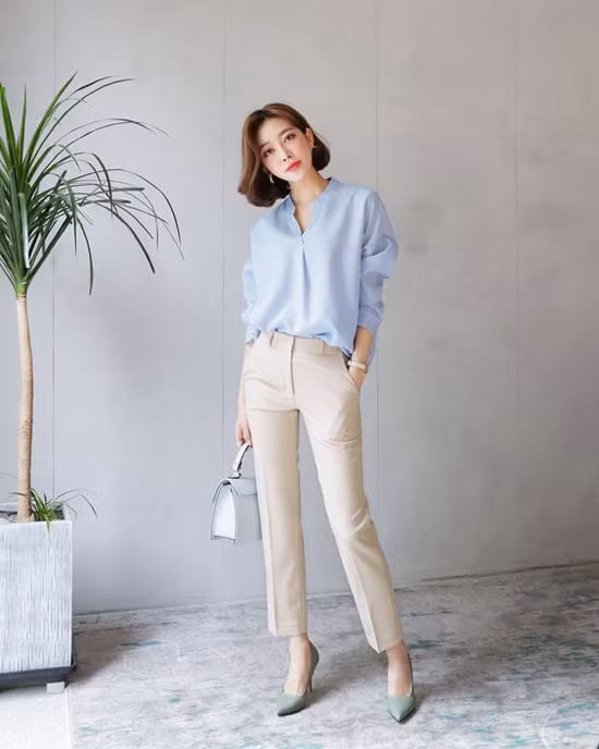 Sắc xanh baby không chỉ 'nịnh da' mà còn khiến người mặc trở nên trẻ trung hơn. Phối cùng mẫu áo cổ trụ là quần âu ống đứng, túi xách tay và giày cao gót kiểu dáng hiện đại. 