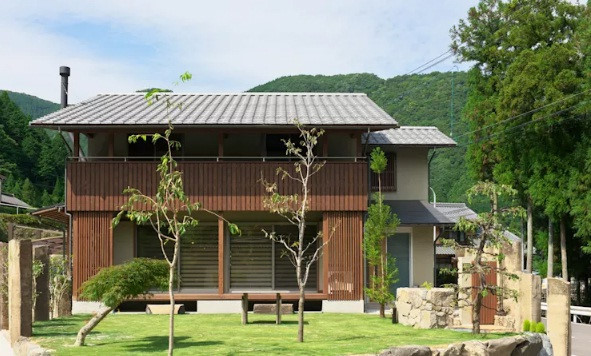 Đặt giữa khung cảnh thiên nhiên xanh mát, ngôi nhà có khoảng hiên được thiết kế mở rộng để bố trí một bộ bàn ghế nhỏ xinh. 