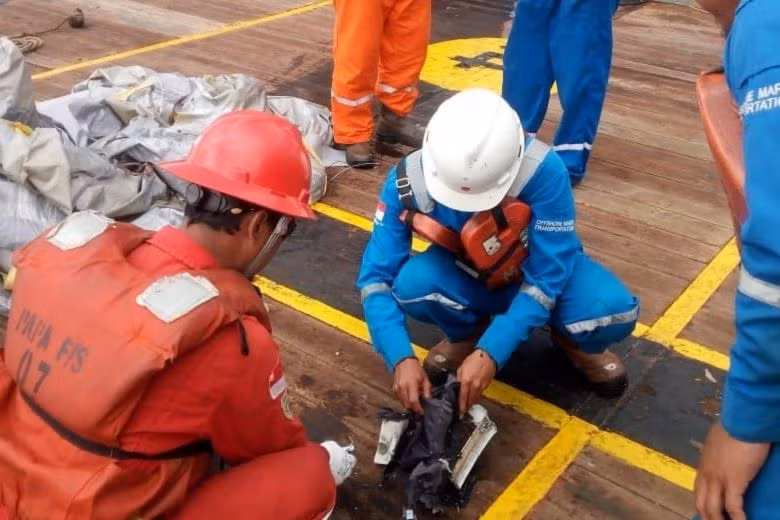 Các nhân viên cứu hộ kiểm tra các vật thể phát hiện được tại vùng biển JT610 rơi