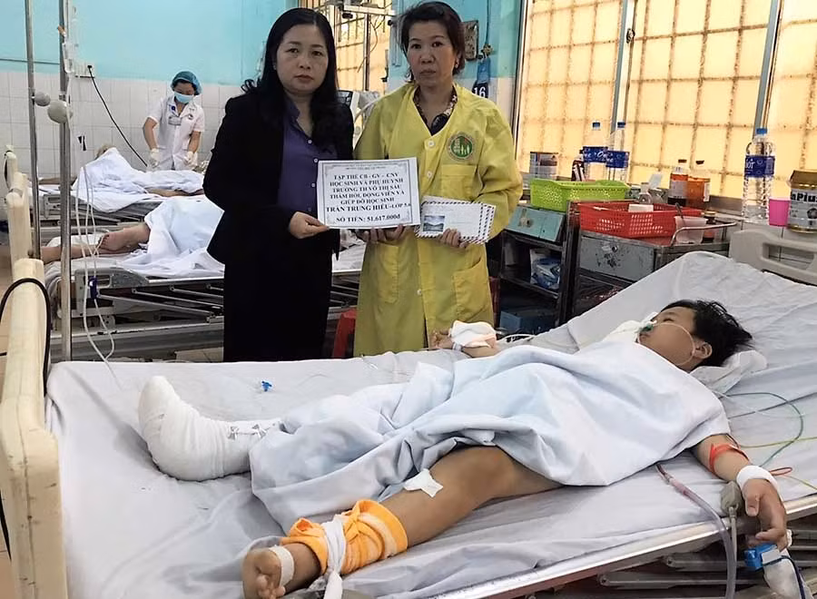  Cô Đồng Thị Thanh Hải (trái)-Hiệu trưởng Trường Tiểu học Võ Thị Sáu trao số tiền nhà trường giúp đỡ cho em Hiếu. Ảnh: Đ.Y