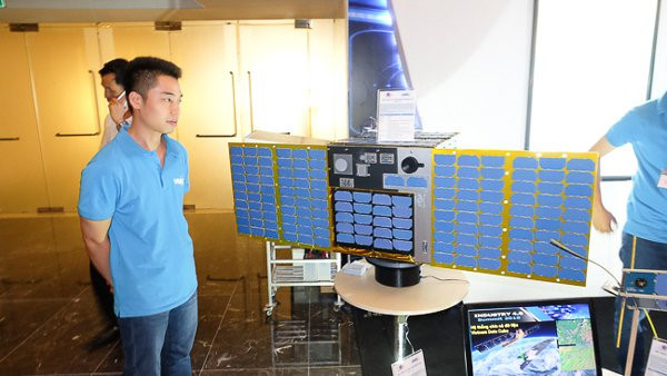Các kỹ sư phát triển bên cạnh mô hình tỷ lệ 1:1 của vệ tinh MicroDragon. Ảnh: Trọng Đạt